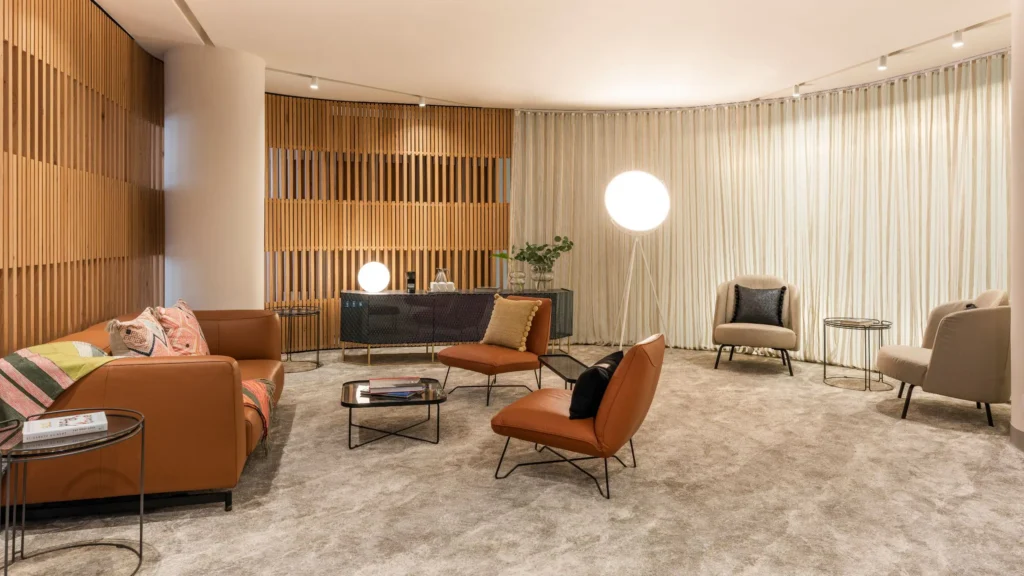 A stylish and cozy lounge area in Andaz Mexico City with plush leather and fabric seating, warm wood paneling, soft lighting, and contemporary decor.