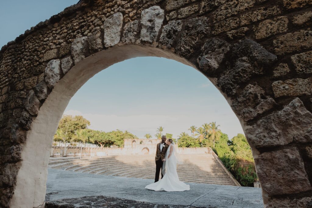 Wedding Couple under a stone arch with at the top of a stone amphitheater