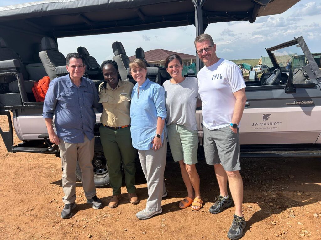 Group photo with safari guide in front of a Land Cruiser at JW Marriott Masai Mara Lodge.