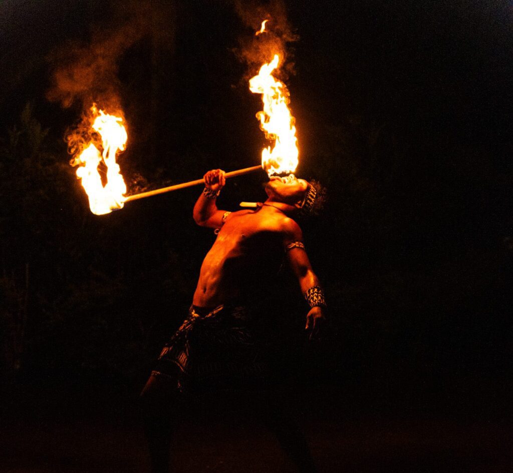 Performer showcasing a traditional Fijian fire dance during an evening celebration at Namale Resort in Fiji.