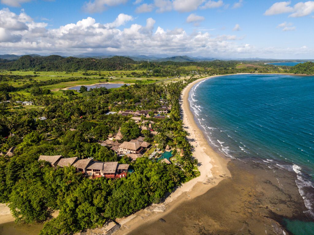 Aerial drone view of Nanuku Resort Fiji beachfront villas along Pacific Harbour coastline