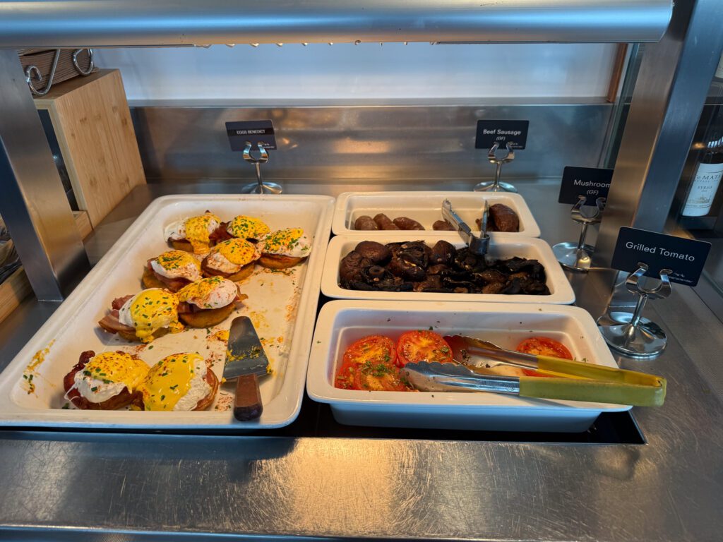 Hot breakfast buffet in the Interislander Premium Lounge with eggs Benedict, sausages, mushrooms and grilled tomatoes.