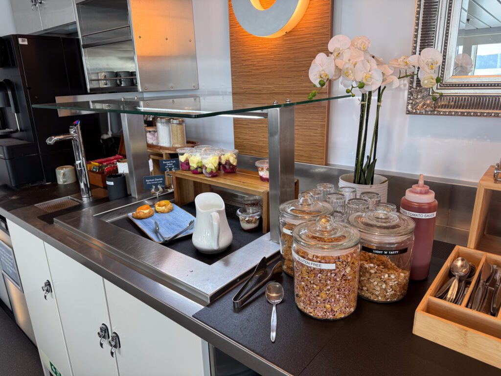 Interislander Premium Lounge breakfast buffet with fruit cups, yogurt, pastries, cereal and hot drinks.