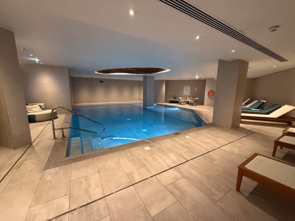 Indoor pool at Hyatt Regency Malta with entry steps and surrounding lounge chairs