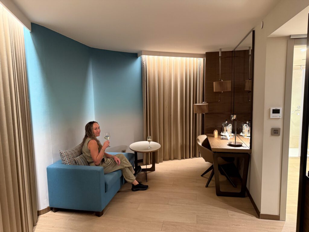 Separate suite living room with a blue sofa, small round table, and desk