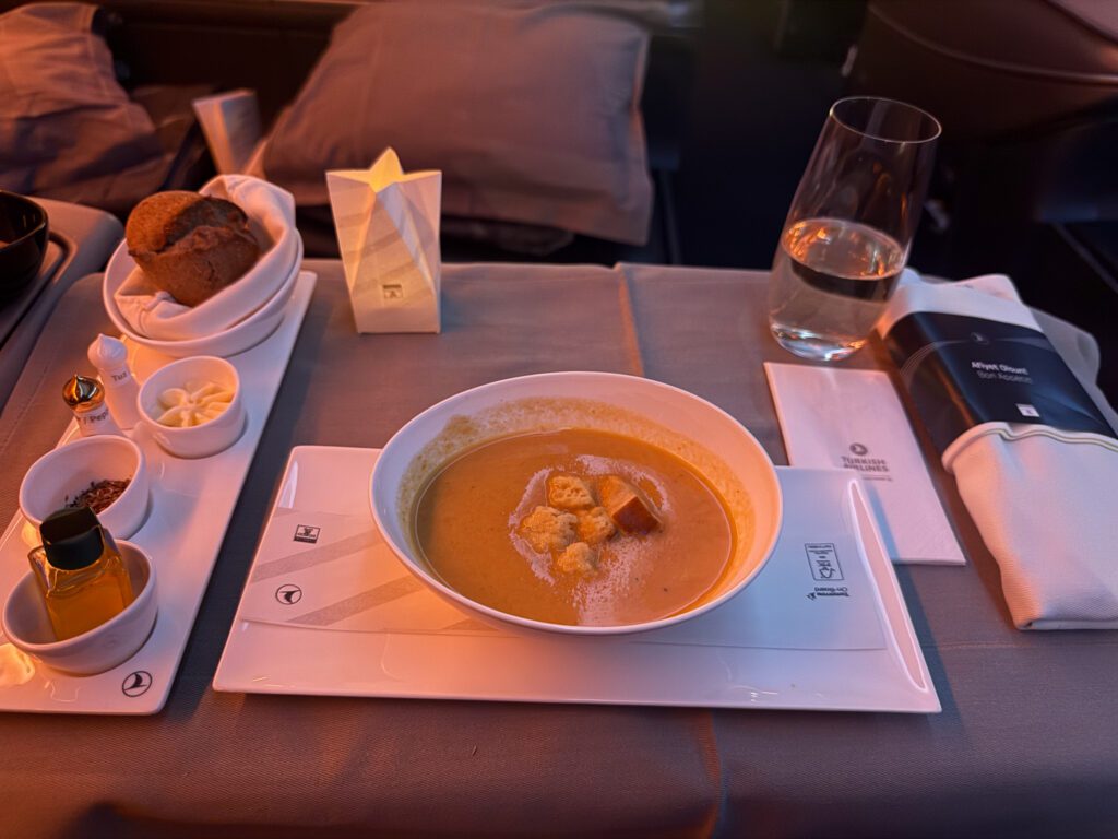 Coriander and carrot soup with croutons, bread, butter and olive oil in Turkish Airlines business class.