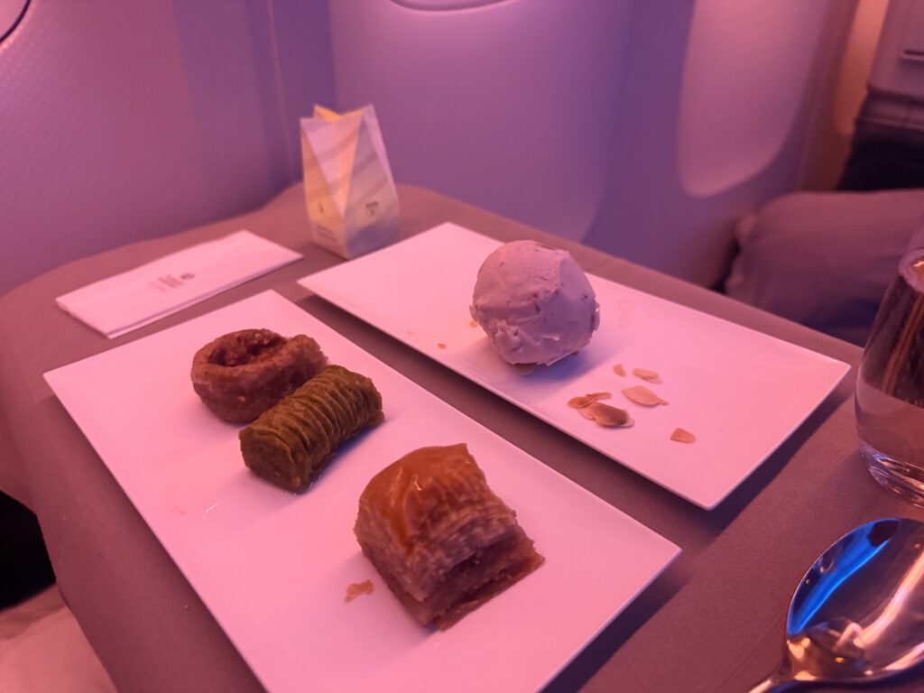 Three Turkish pastries on a rectangular plate beside a scoop of ice cream.