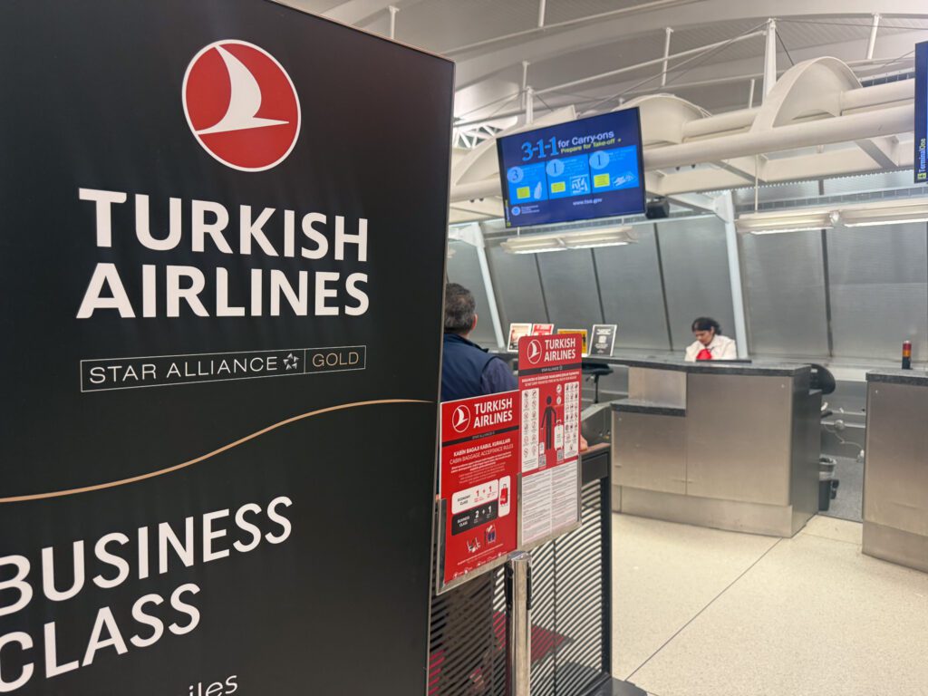 Turkish Airlines business-class and Star Alliance Gold sign at the JFK check-in counter.